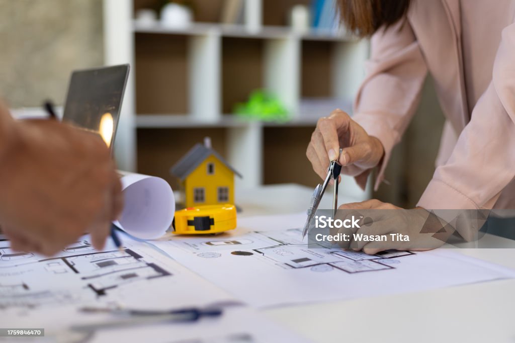 Group of young architects colleagues brainstorm design work on blueprint planning ideas of construction projects. Construction engineering design inspector team working in the office.