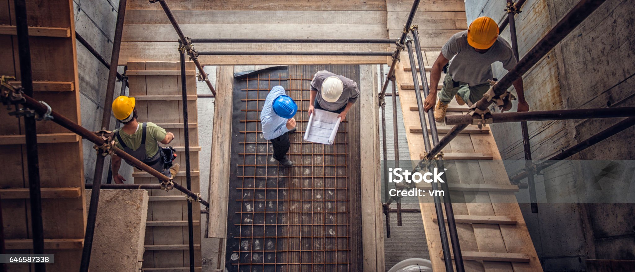 Construction workers and architects at a construction site viewed from above.